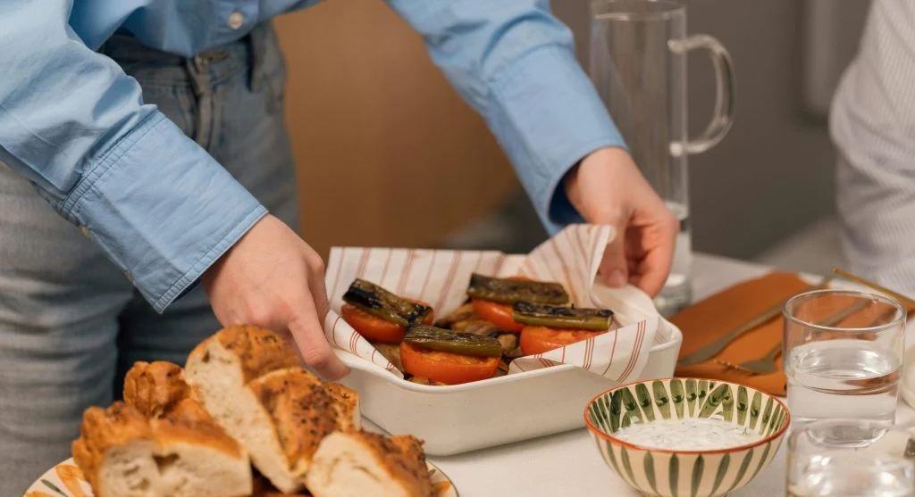 A family-style meal of soup, toast, fruit, and salad