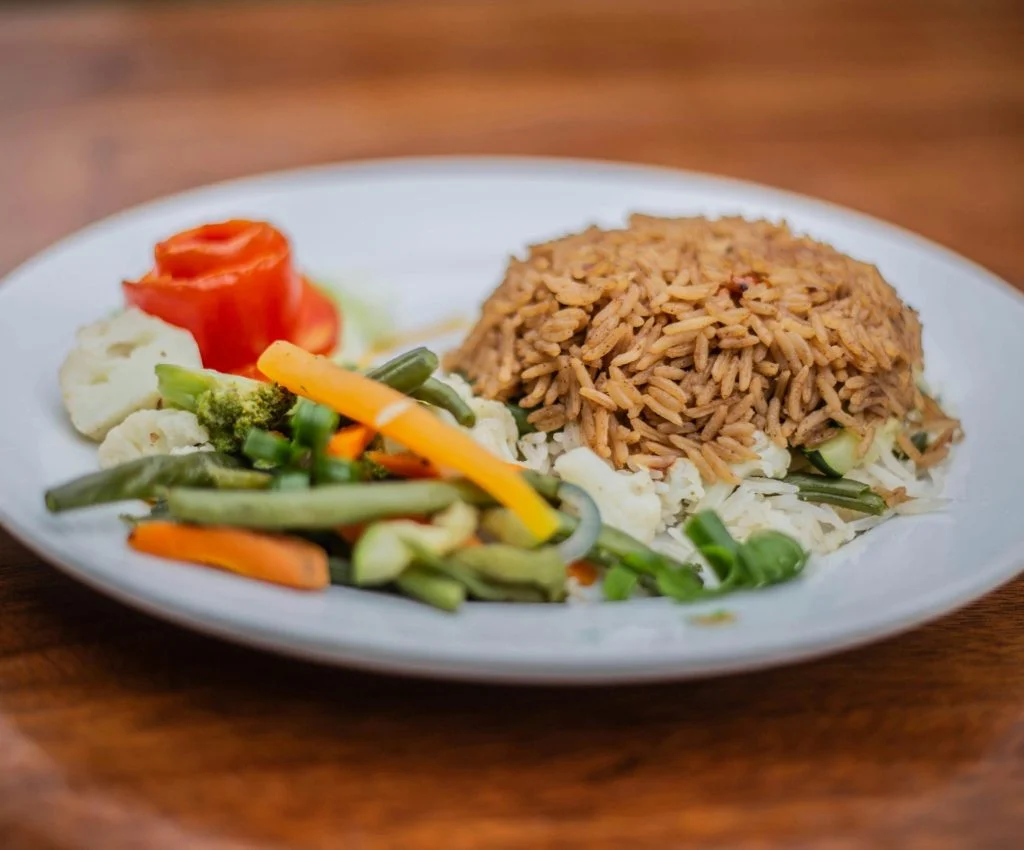 A plate of rice, chicken, and vegetables for a healthy afternoon meal