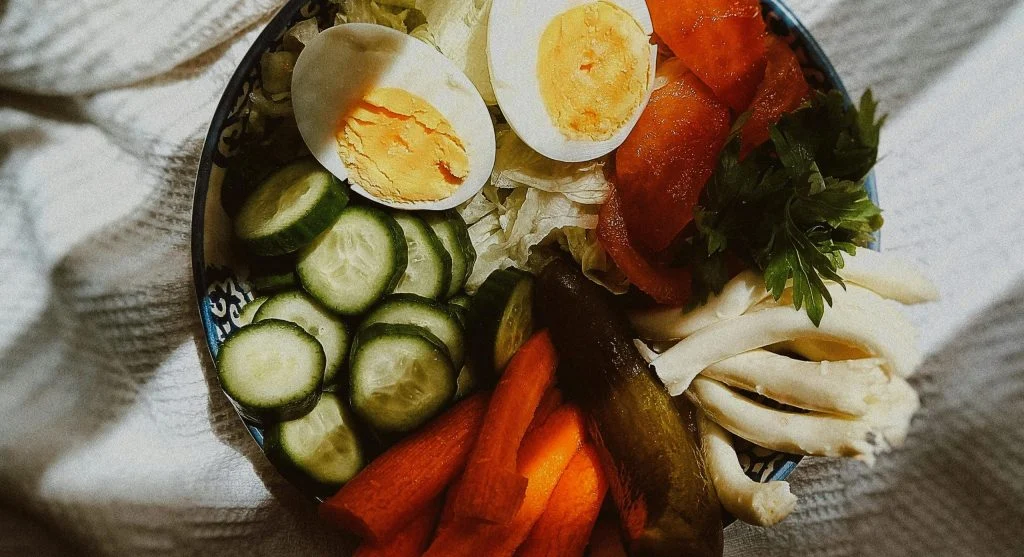 Healthy bites for study sessions with boiled eggs crackers and cucumber beside books