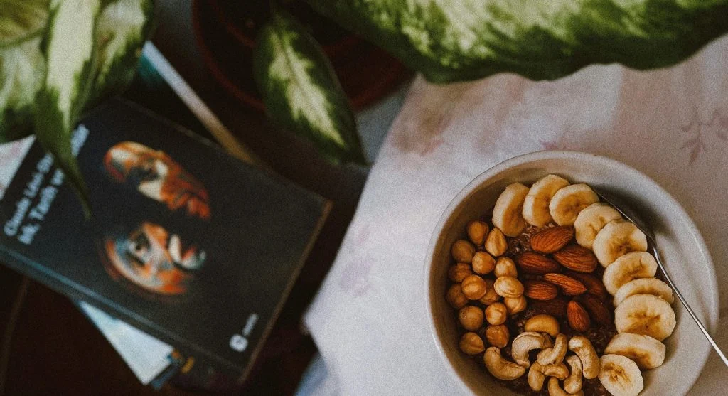 Person enjoying a balanced snack with a warm beverage on a rainy day