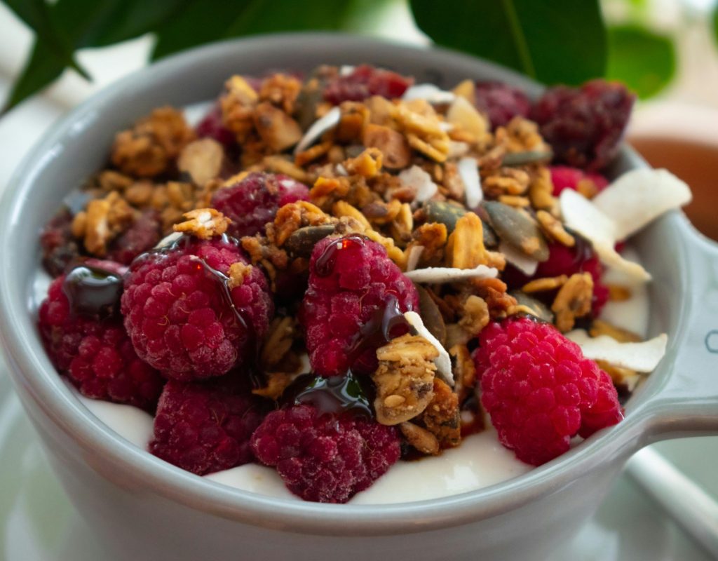 Greek yogurt topped with mixed berries, oats, and food picks