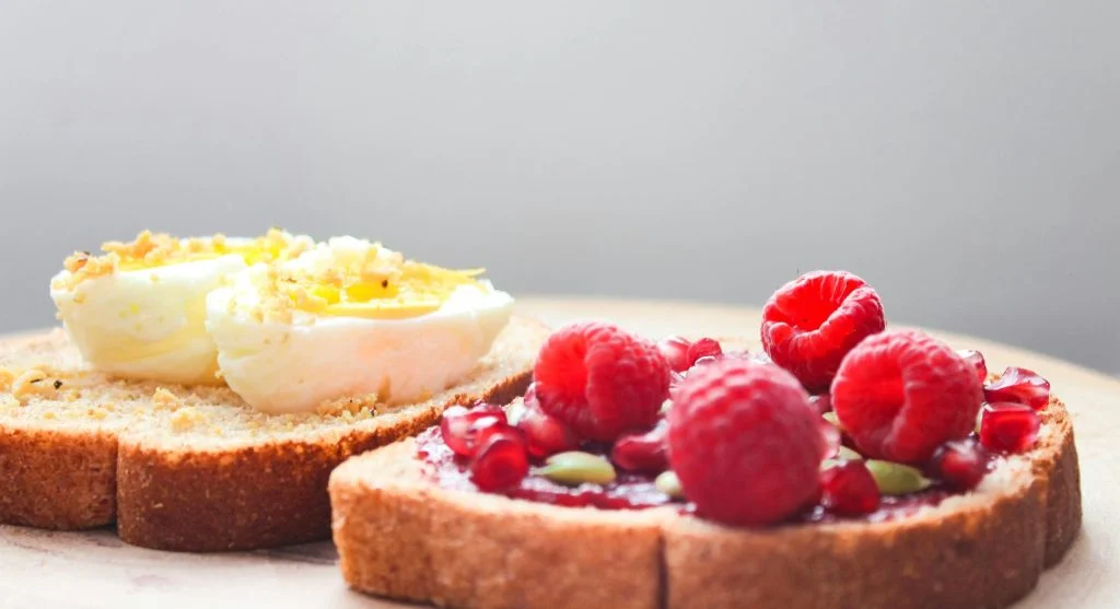 Eggs, toast, berries, and yogurt on a plate